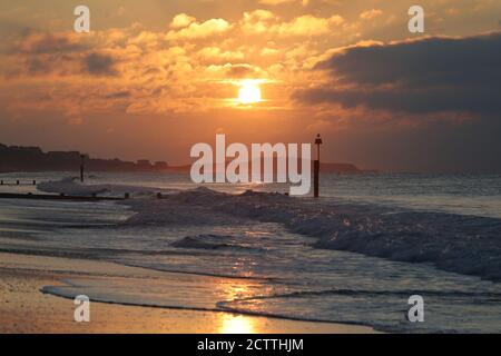 Die Sonne über Boscombe Strand in Dorset. Stockfoto