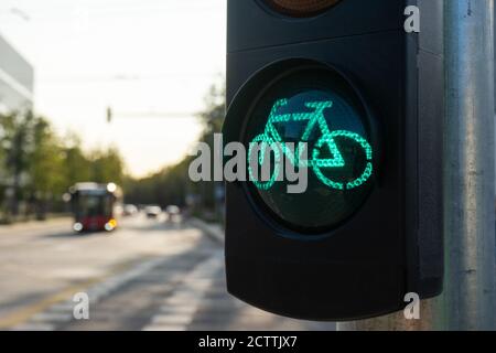 Ampel für Fahrräder an einem sonnigen Sommertag mit verschwommenem Blick auf die Stadt im Hintergrund. Grünes Licht für Sportkonzept. Gesundes Leben Stockfoto