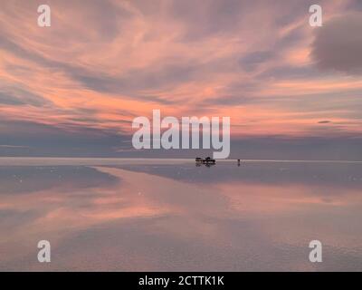 Sanfter Sonnenuntergang über dem Salzsee Salar de Uyuni, Bolivien. Erstaunliche Himmel Wolken Reflexion im Wasser. Naturwunder. Einzigartig schöne Wildnis Natur. Stockfoto