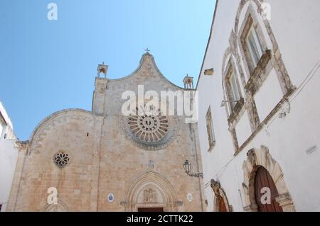 Das Gesicht der Kathedrale von Ostuni in Apulien und einige Andere Gebäude neben blauen und klaren Sommerhimmel oben Stockfoto