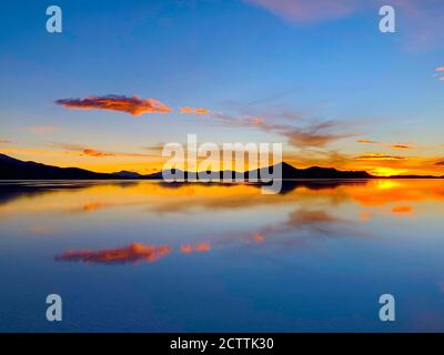 Spektakuläre Sonnenuntergangsspiegelung im Salzwasser. Dramatischer Sonnenuntergang. Wüstensee Salar de Uyuni. Farbiger Himmel. Wunderschöne Sonnenuntergänge in den bolivianischen Anden Stockfoto