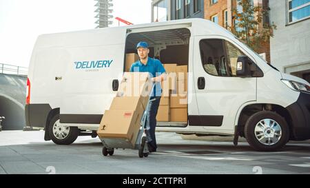 Delivery man schiebt Hand Truck Trolley voll von Karton-Boxen Hände Paket an einen Kunden. Courier liefert Paket an man im Business District. Stockfoto