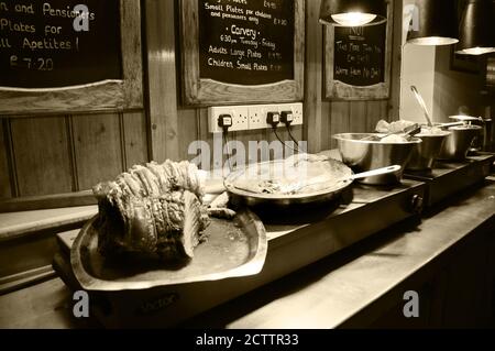 EAST ENGLAND, Großbritannien - 18. AUGUST 2017: Abendessen in der Fleischkälge in der alten Gaststätte in Norfolk. Beef Joint und andere Gerichte der traditionellen englischen Küche. Preise. Sepia Stockfoto