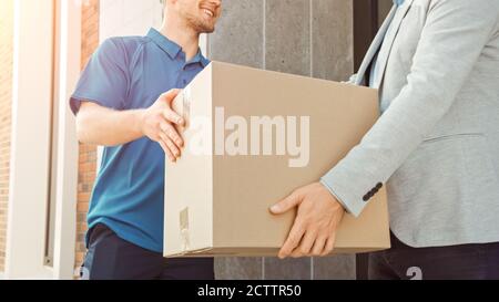 In stilvollen modernen städtischen Office Area Delivery man liefert Postpaket an einen männlichen Business-Kunden. Stockfoto