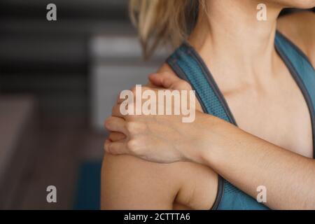 Nahaufnahme der Fitness Frau mit Schmerzen in der Schulter. Schmerzen nach dem Training zu Hause Stockfoto