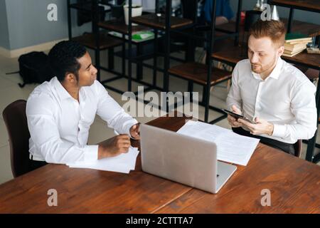 afroamerikanische und kaukasische europäische junge Geschäftsleute diskutieren neues Projekt Stockfoto