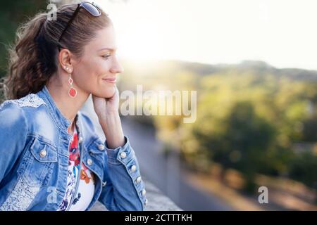 30s Frau denkt über Liebe, Tagträumen im Park Stockfoto