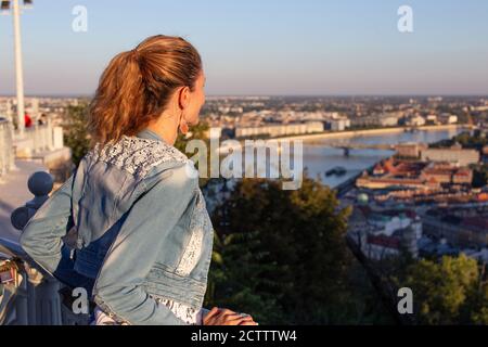 Junge Stadtfrau wundert sich in der Stadt Panorama Sonnenuntergang Stockfoto