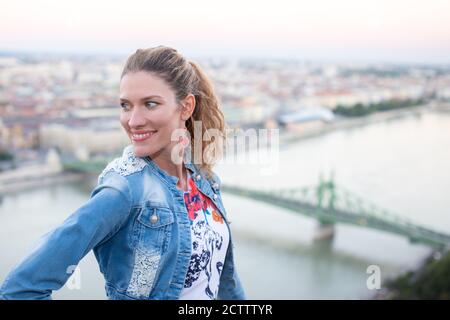 Junge fröhliche Frau, die auf Budapest Panorama, Ungarn, schaut Stockfoto