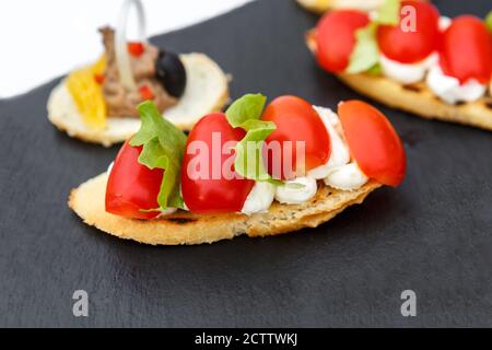 Sandwiches mit Tomaten, Salat und Oliven auf einem Schieferteller Stockfoto