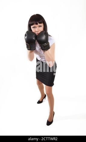 Mädchen in Bürokleidung und Boxhandschuhe auf einem weißen Hintergrund Stockfoto