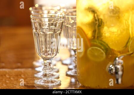 Glasbecher mit Fruchtgetränk und leeren facettierten Gläsern Stockfoto