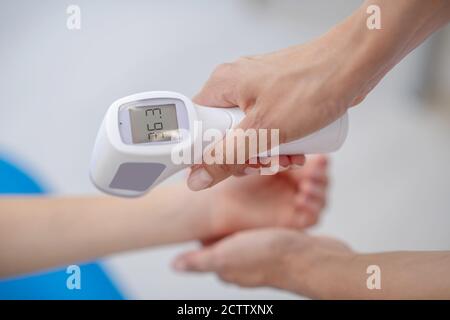 Nahaufnahme des Arztes, der die Temperatur der Kinder überprüft Stockfoto