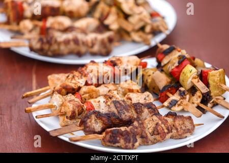 Der Schischkebab auf den hölzernen Spieß liegt auf dem Teller bestreut Mit Zwiebeln Stockfoto
