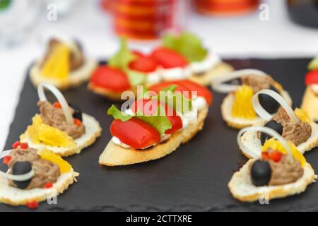 Sandwiches mit Tomaten, Salat und Oliven auf einem Schieferteller Stockfoto
