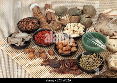 Traditionelle chinesische Kräutermedizin mit Akupunkturnadeln & Kräuter- & Gewürzauswahl auf Bambus. Alternative Gesundheitsversorgung Konzept. Stockfoto