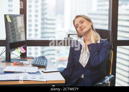 Business Frau Nackenschmerzen von langjähriger harter Arbeit im Büro. Stockfoto