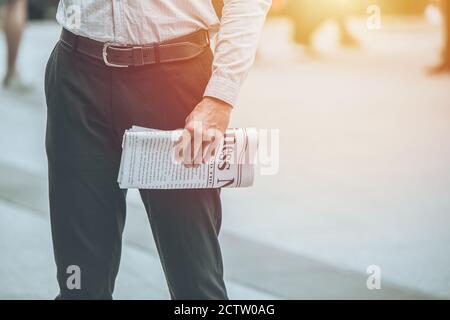 Geschäftsmann Hand hält Mockup gefälschte Business News Papier für jeden Morgen mit Platz für Text lesen. Stockfoto