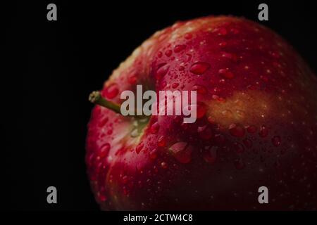 Roter und saftiger Apfel mit Wassertropfen Makro Hintergrund Stockfoto