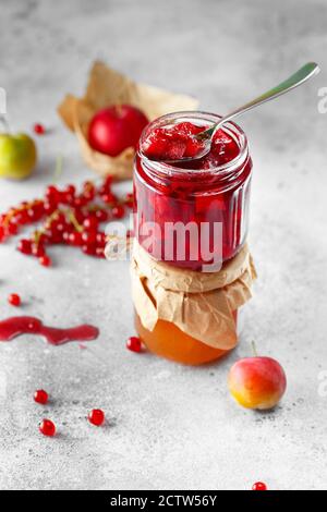 Löffel köstliche Fruchtkonfitüre. Zwei Gläser Obst hausgemachte Marmelade. Glasgefäße mit verschiedenen Arten von Marmelade und Beeren. Pflaume und rote Johannisbeere konfitüren Stockfoto