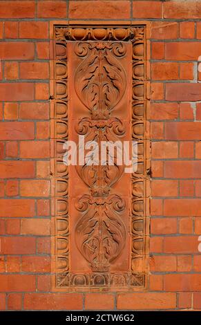 Dekorative florale Design-Effekt auf Terrakotta-Stil Ziegelwand, fakenham, norfolk, england Stockfoto