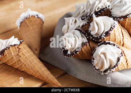 Viele Eiszapfen auf einem Holztisch. Weiches Eis oder gefrorene Cremes in Zapfen. Eiscreme mit Waffel-Marshmallow Stockfoto