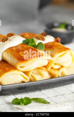 Russische dünne Pfannkuchen mit Hüttenkäse und Rosinen. Gesundes traditionelles Frühstückskonzept Stockfoto