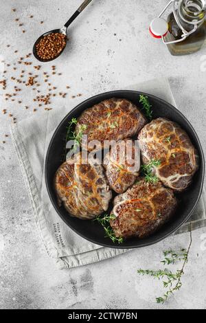 Köstliche gegrillte Leberfleischbällchen mit Buchweizen in einer natürlichen Hülle. Leberpasteten auf der kleinen Bratpfanne mit Thymian serviert. Food-Fotografie. Flach Stockfoto