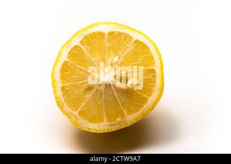 Frische Zitrone mit der Hälfte und Blätter isoliert auf weiß Stockfoto