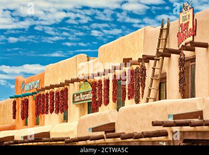 Ristras Paprika Chilis bei Adobe Gebäude am Plaza in Taos, New Mexico, USA Stockfoto