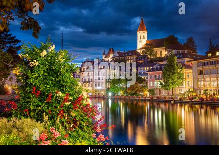 Thun, Schweiz. Stadtbild der schönen Stadt Thun mit der Reflexion der Stadt in der Aare Fluss in der Nacht. Stockfoto