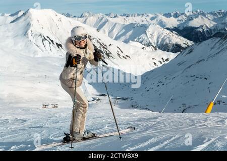 Junge Erwachsene schön glücklich attraktiv kaukasisch lächelnd Skifahrer Frau voll Länge Körperportrait Berggipfel zeigt Skigebiet Panorama Stockfoto