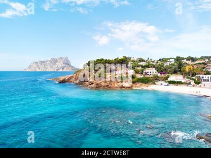 Türkisfarbene Bucht des Mittelmeers von Benissa spanischer Ferienort. Weißer Sand am Strand, Häuser am Hang. Provinz Alicante, Costa Blanca, Spanien Stockfoto