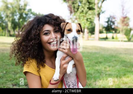 Selektiver Fokus der jungen Frau, die Hund hält und anschaut Kamera Stockfoto