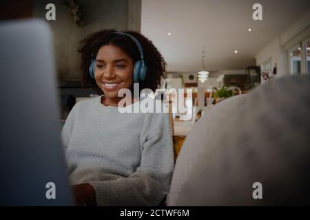 Schöne Frau entspannen und Musik hören mit Kopfhörern mit Notebook Stockfoto