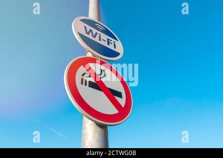 Mast mit Zeichen für Wireless Internet Hotspot und rauchfreie Zone Stockfoto