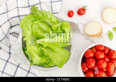 Blick von oben auf den frischen Salat, Kirschtomaten und Zwiebeln bereit, einen Salat vorzubereiten. Frisches und gesundes Gemüse Stockfoto