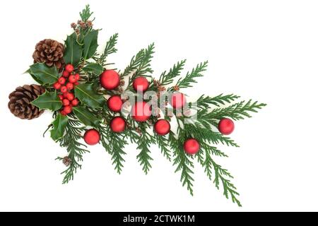 Weihnachtliche Deko mit Winterstachelchen, Tannenzapfen, Zedernkypresse & roten Kugeln auf weißem Hintergrund. Festliches Themenelement. Stockfoto