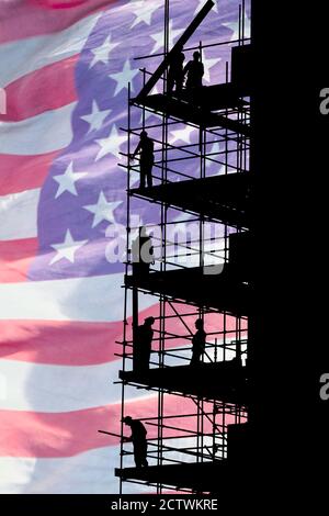 Bauarbeiter auf Gerüsten mit Stars and Stripes Flagge als Hintergrund. Konzeptbild: USA, amerikanische Wirtschaft, Arbeiter... Stockfoto