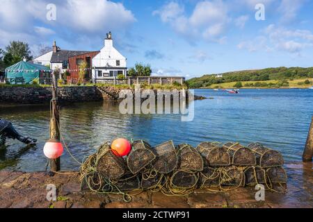 Hummertöpfe am Steg mit Badachro Inn im Hintergrund im ehemaligen Fischerdorf Badachro, Gairloch, Wester Ross, Highland Region, Schottland, Großbritannien Stockfoto