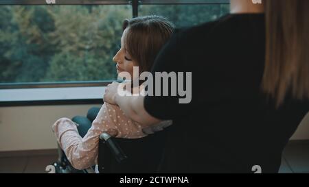 Junge behinderte Frau, die über die Schulter auf ihre Betreuerin schaut. Hochwertige Fotos Stockfoto