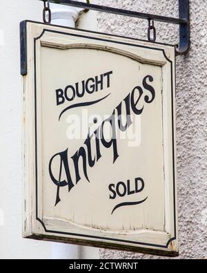 Nahaufnahme eines Antiquitätenkaufs und -Kaufs-Schildes, das über einem Antiquitätenladen in Großbritannien hängt. Stockfoto