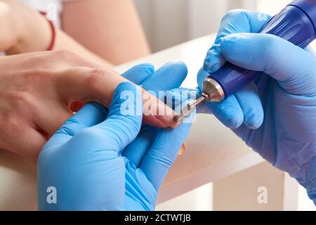 Maniküre Master verwendet eine elektrische Nagelmaschine, um Nagellack Hände im Nagelstudio zu entfernen Stockfoto