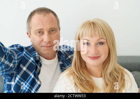 Selbstportrait eines reifen Paares in der häuslichen Einrichtung auf dem Sofa. Stockfoto
