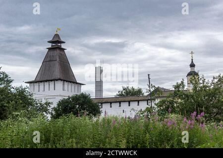 Ein quadratischer Turm und weiße Wände mit Schlupflöchern. Hölzerne Walmdach über den Türmen. Panfutjewski Kloster in Borowsk, Russland. Stockfoto