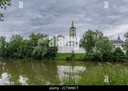 Der Glockenturm, Mauern, Türme mit Schlupflöchern spiegeln sich im Wasser. Blick vom Teich. Panfutjewski Kloster in Borowsk, Russland. Stockfoto