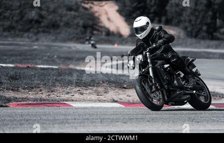 Motorradfahrer bei Sportfahrrad Fahrten durch leere Asphaltstraße. Sportfahrrad. Stockfoto