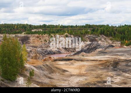 Ungewöhnlich schöne Herbstlandschaft mit roten Seen, bunten Hängen und Wald. Ural Mars. Graue Wolken bewegen sich im bewölkten Himmel. Stockfoto