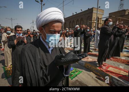 25. September 2020, Irak, Sadr City: Muslime halten ihre soziale Distanzierung aufrecht, während sie Gesichtsmaske und Handschuhe tragen, während sie die Freitagsgebete nach monatelanger Aussetzung aufgrund der Ausbreitung der Coronavirus-Pandemie (COVID-19) durchführen. Foto: Ameer Al Mohammedaw/dpa Stockfoto