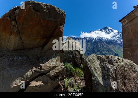 Trinity Kirche auf dem Berg vor dem Hintergrund von Felsen Im Dorf Gergeti an der georgischen Militärstraße Stockfoto